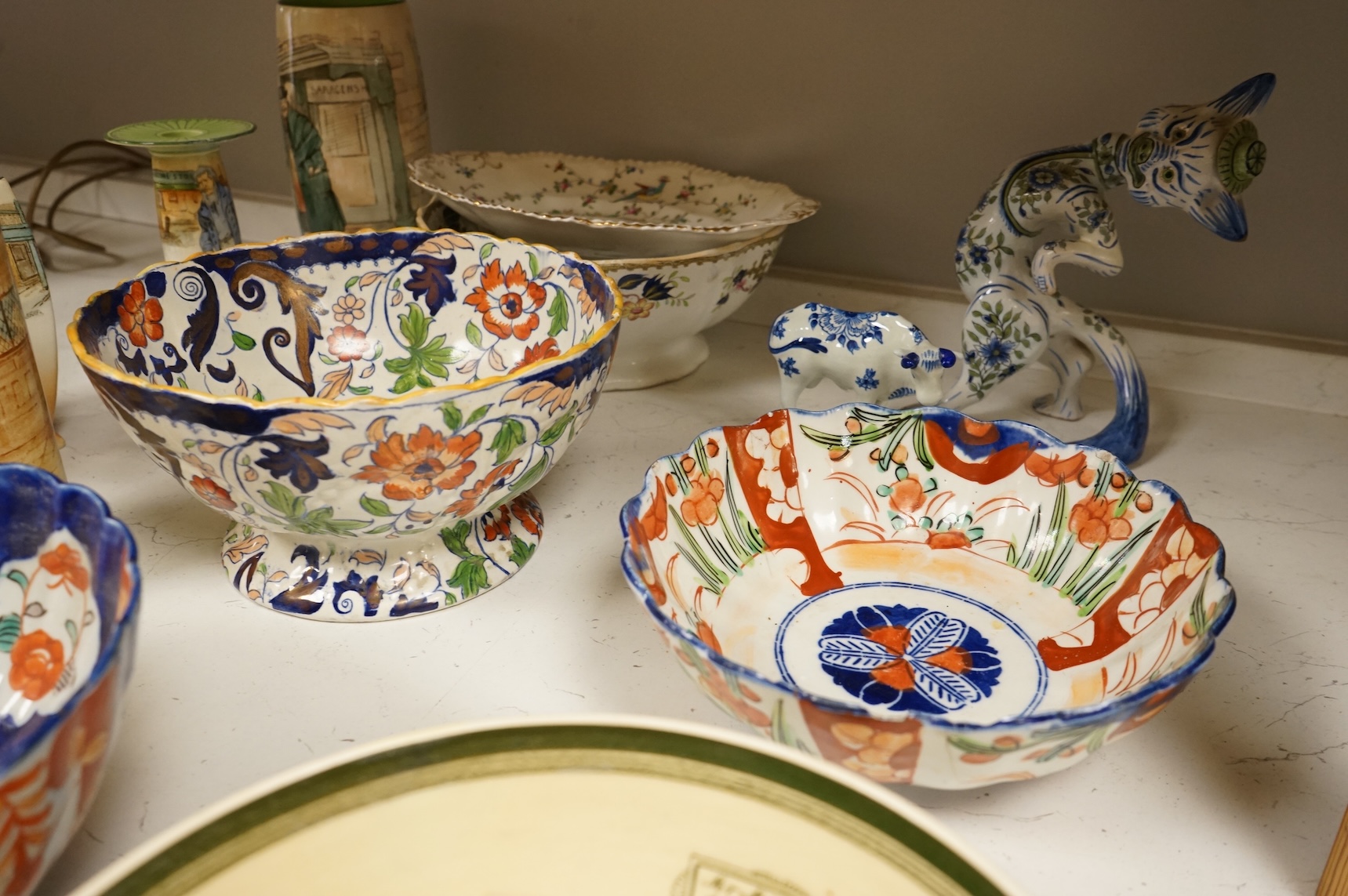 A collection of French, Japanese and English ceramics to include Royal Doulton Dickensware, Imari bowls and a faience glazed cat